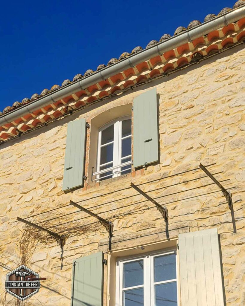 Support façade glycine Support de treille et pergola suspendue en fer forgé sur façade en pierre pour plantes grimpantes