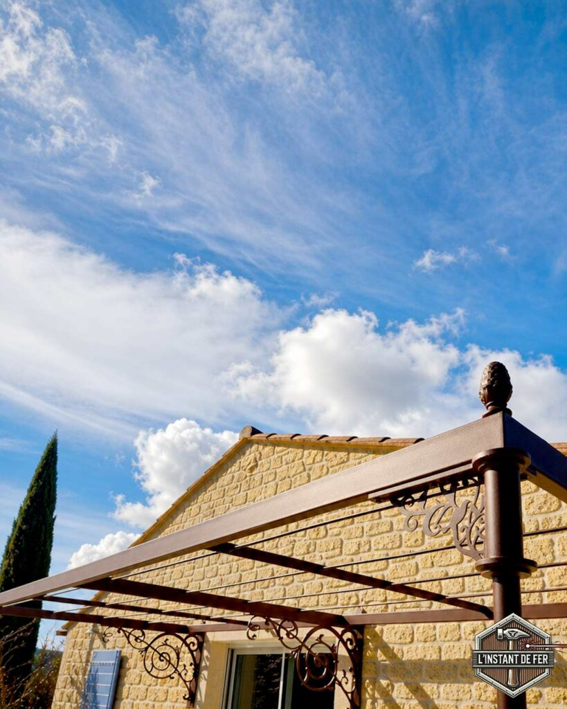 Pergola en acier avec volutes décoratives Détail d'une pergola en acier avec volutes décoratives et finition pomme de pin